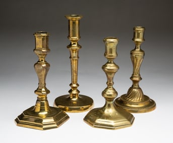 FOUR EUROPEAN BRASS CANDLESTICKS.
