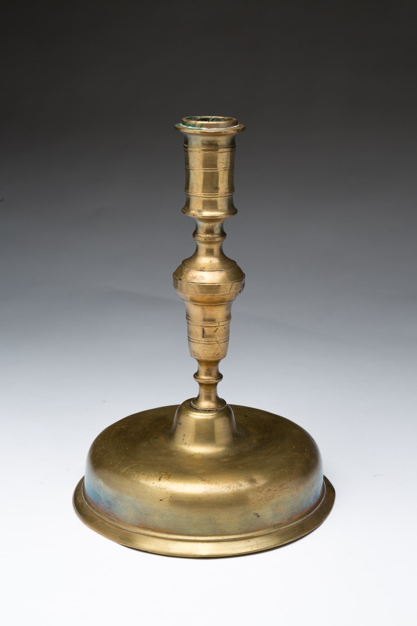 EUROPEAN BRASS CANDLESTICK.: Ca. 1690. Round stepped base, baluster column and round socket with flared rim. 9.25"h. Ex Peter Chillingworth.Provenance: From the Collection of Peggy McClard & Randy Segotta (Weare, New Hampshire).