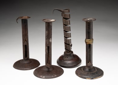 IRON COURTING CANDLESTICK AND THREE TIN HOGSCRAPER CANDLESTICKS.