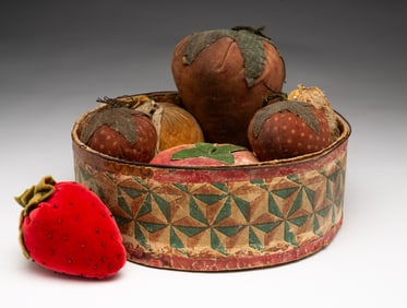AMERICAN WALLPAPER BAND BOX FILLED WITH VELVET AND CLOTH FRUIT PINCUSHIONS AND AN EMERY.