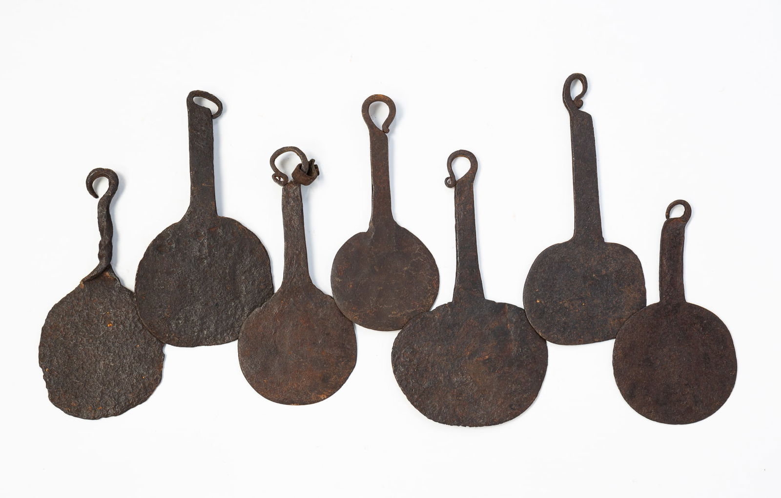 SEVEN AMERICAN WROUGHT IRON SPATULAS.: Early 19th Century. With round heads and loops at the ends of handles. 6.5"l. to 5.5"l.Provenance: From the Collection of Peggy McClard & Randy Segotta (Weare, New Hampshire).