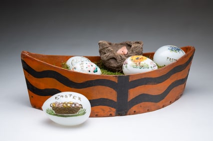 PAINT-DECORATED WOOD BASKET FILLED WITH GLASS EASTER EGGS AND A BIRD'S NEST.