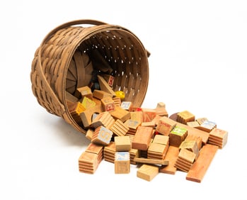 AMERICAN SPLINT-WOVEN BASKET FILLED WITH WOOD BLOCKS AND TOYS.
