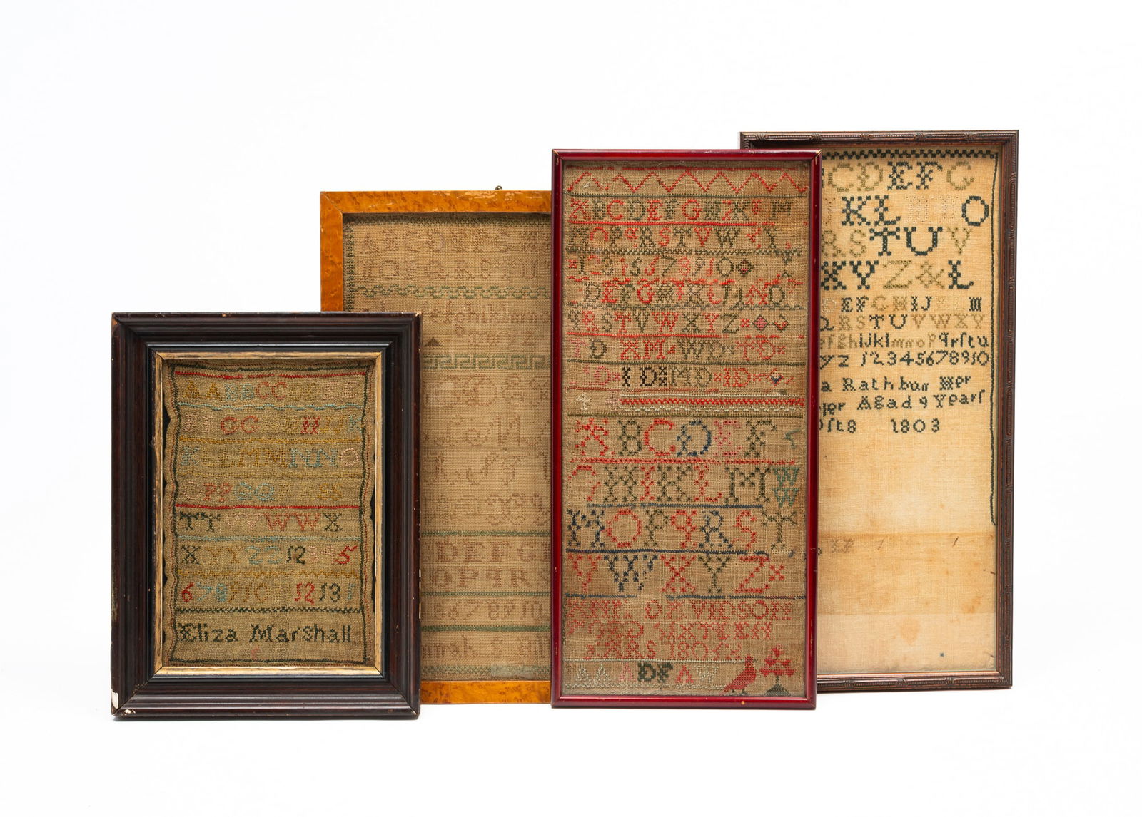 FOUR AMERICAN NEEDLEWORK SAMPLERS.: 19th Century. Colored thread on linen. All with alphabets and numerals. Signed by Lydia Rathburn in an intricate frame behind glass, 18"h. 9"w. Signed Hannah S. Bills in a bird's-eye maple frame behin