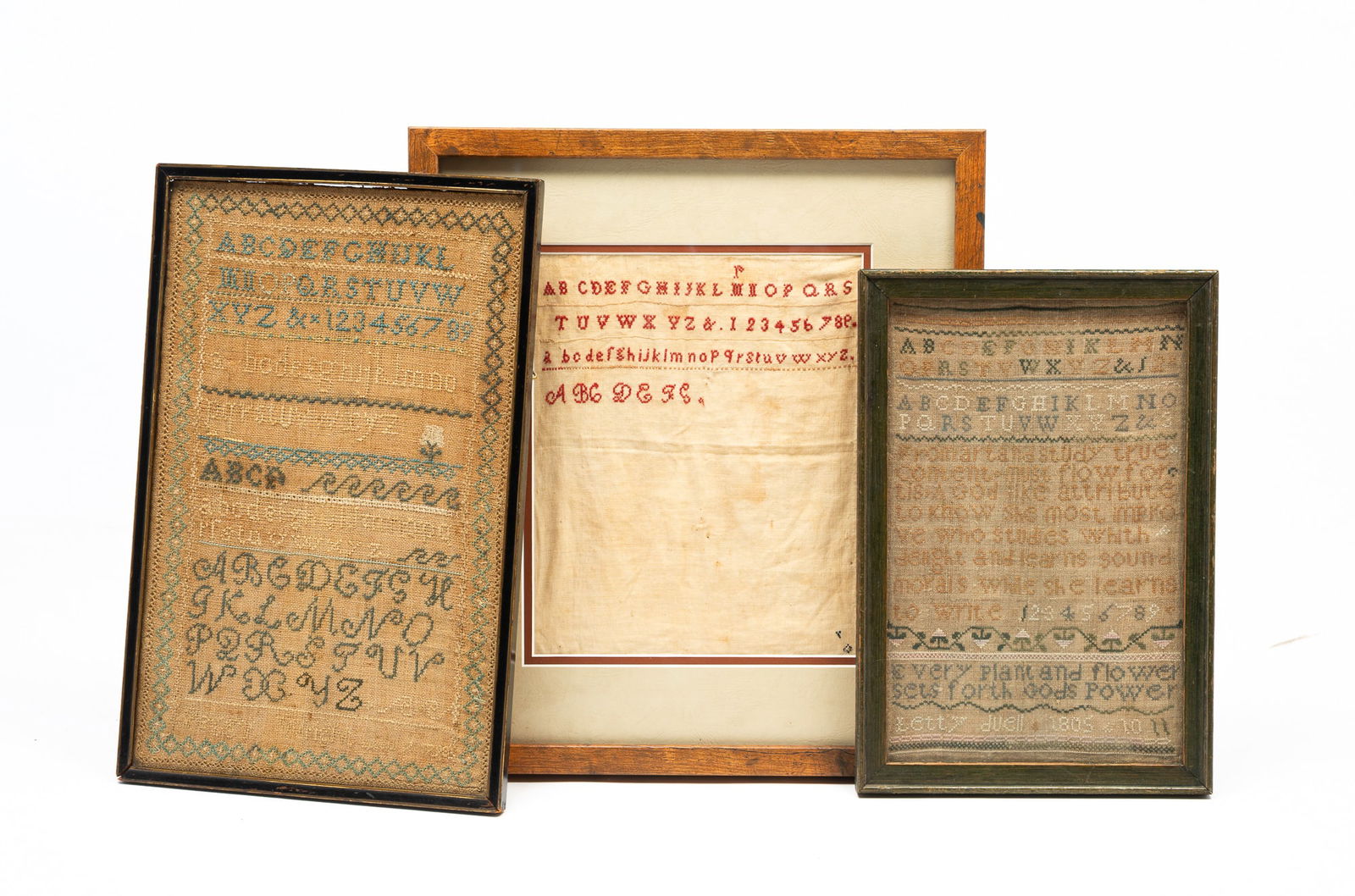 THREE AMERICAN NEEDLEWORK SAMPLERS.: Colored thread on linen. All with alphabets and numerals. One signed Peggy Wright and dated 1798 with blue border and a flower, in a black paint frame behind glass, 15.75"h. 10.25"w. A plain sampler w