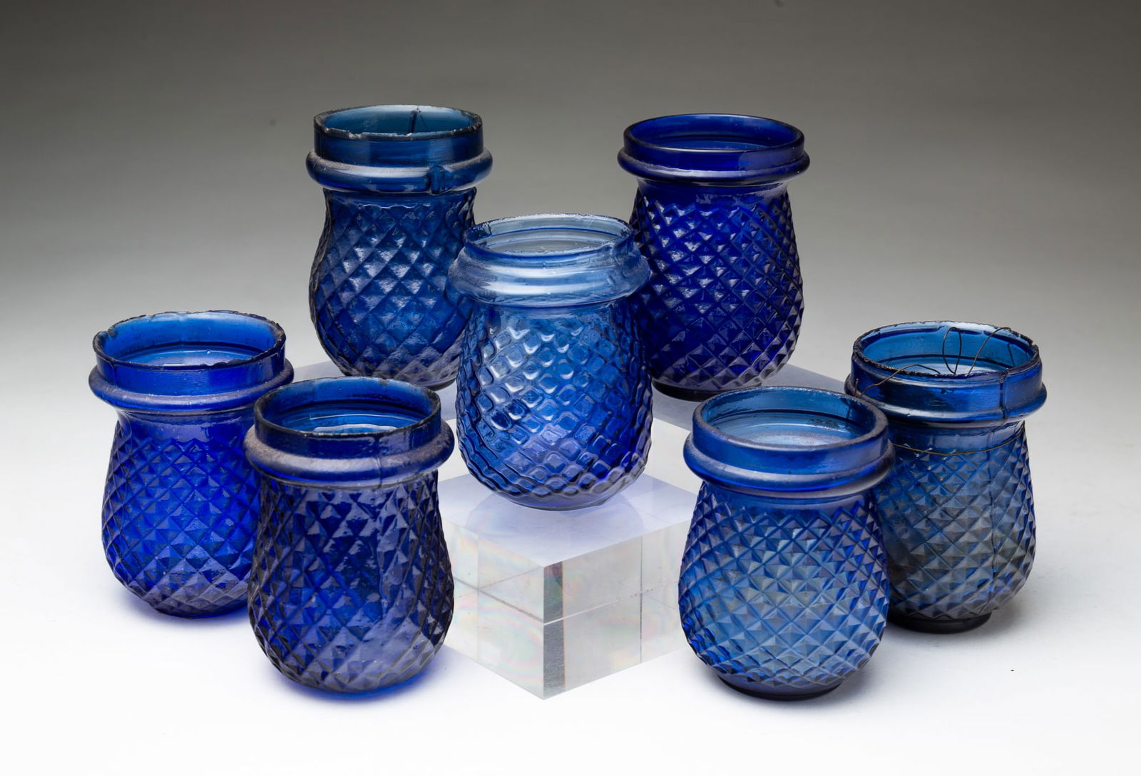SEVEN AMERICAN COBALT GLASS CHRISTMAS TREE LANTERNS.: Late 19th Century. All in cobalt with quilted pattern, 3.5"h.Provenance: From the Lifetime Collection of Ronald & Kathy Wright (Willoughby, Ohio). PLEASE TAKE NOTE OF OUR SHIPPING OPTIONS PRIOR TO BID