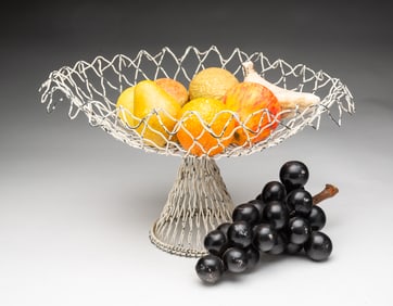 GROUP OF STONE FRUIT IN WIRE COMPOTE.