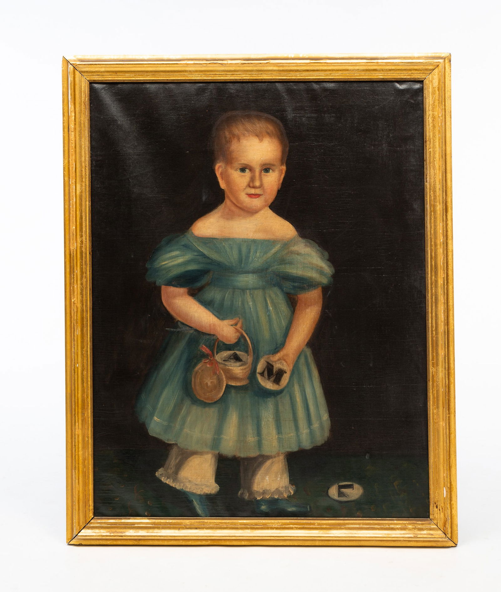 AMERICAN SCHOOL FOLK ART OIL ON CANVAS PORTRAIT OF A YOUNG CHILD.: 19th Century. A full-length portrait of a young boy holding a basket with plates and wearing a blue dress. Unsigned. 32.5"h. 25"w. In a gilt frame, 36"h. 28.5"w.Provenance: From the Lifetime Collectio