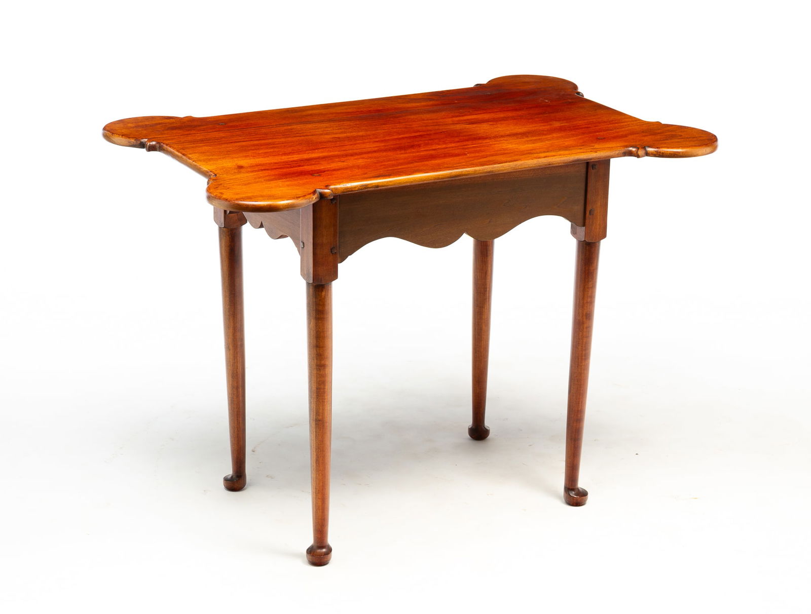 DAVID T. SMITH & CO. (MORROW, OHIO) QUEEN ANNE STYLE MAPLE TEA TABLE.: American, late 20th Century. Shaped one board top with biscuit corners, scalloped apron, round tapering legs ending in pad feet, pegged construction, etched label on underside. 26.25"h. 36"w. 23.25"d.