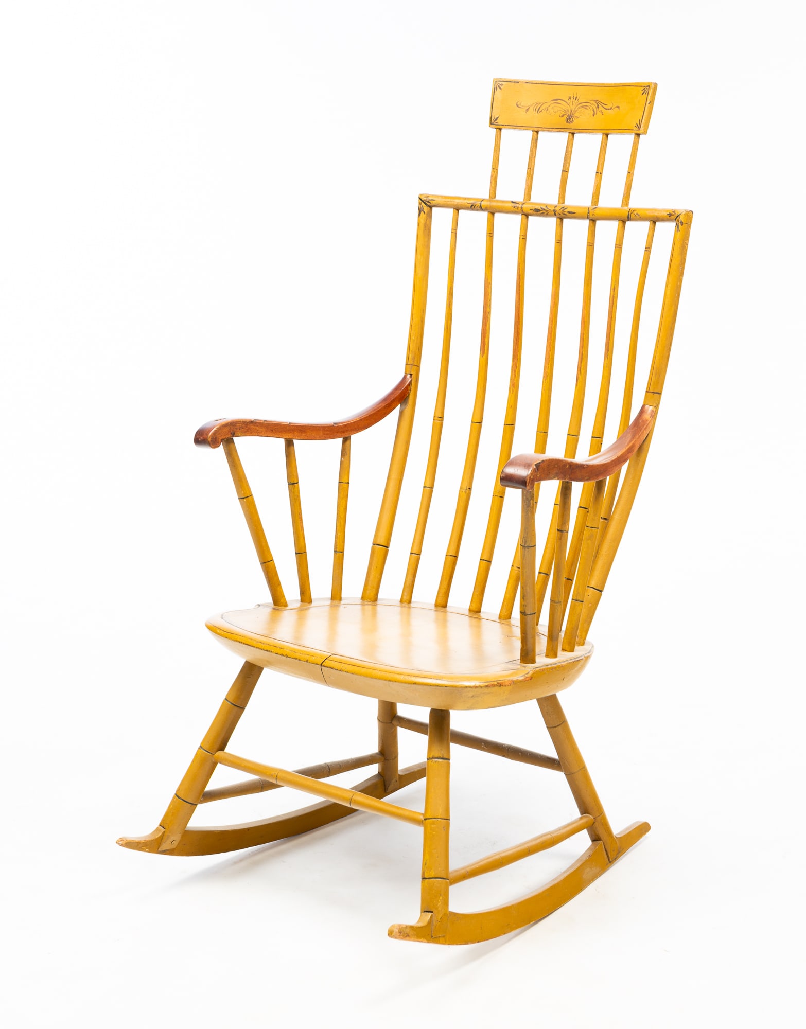 AMERICAN MUSTARD-PAINTED ROD-BACK WINDSOR ROCKER WITH COMB.: 19th Century. Mixed woods. Having bamboo-turned crest rail with comb above a rod back flanked by scrolled arms and continuing to a plank seat, turned legs, and rocker rails. 42.5"h. 22.5"w. 25.5"d.