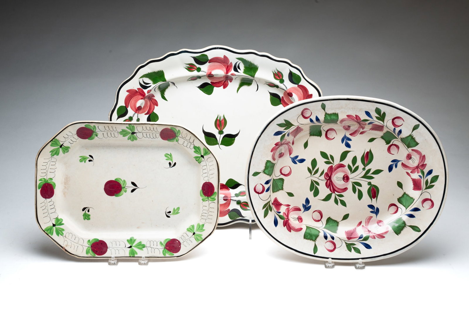 THREE IRONSTONE PLATTERS, INCL. HALL.: American and English, 19th Century. Platter of oval form with foliate rim and decorated with red roses and green leaves, impressed mark on underside. 14.5"h. 17.5"w. Hall platter of oval form