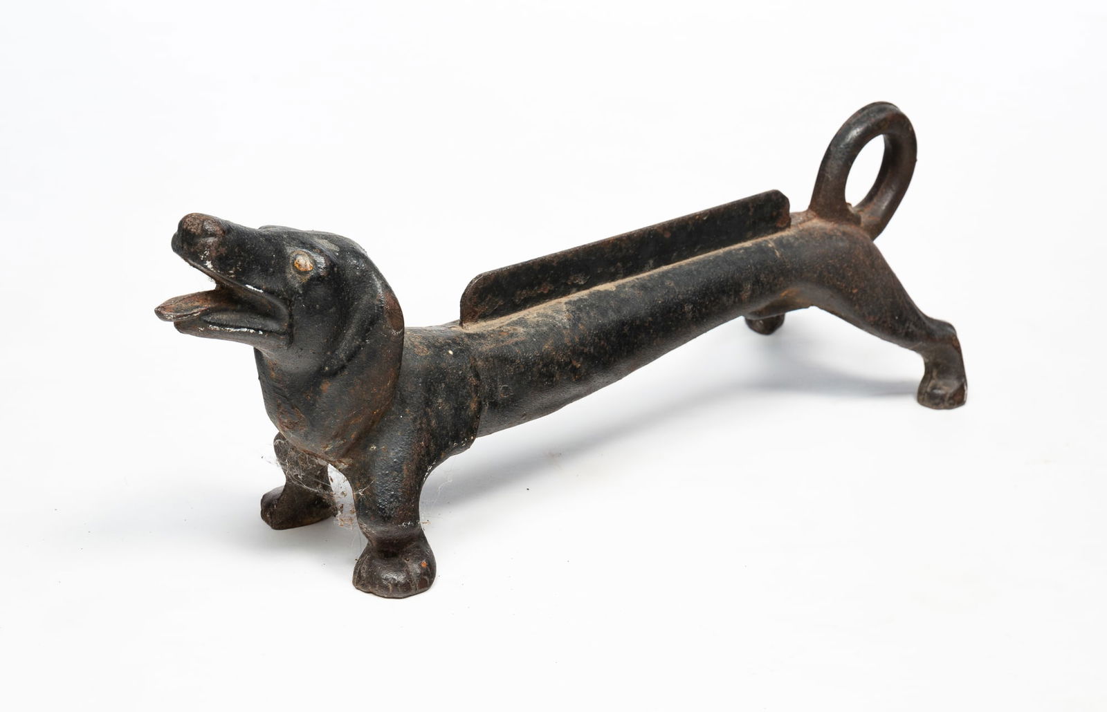 AMERICAN PAINTED AND CAST IRON DACHSHUND BOOT SCRAPER.: 20th Century. Depicting a dachshund with an open mouth, cast tongue, elongated body, curled tail, and short legs. Unmarked. 7.75"h. 6.75"w. 22"d.Provenance: From the Lifetime Collection of the late De