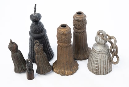 SEVEN AMERICAN CAST METAL TASSELS.