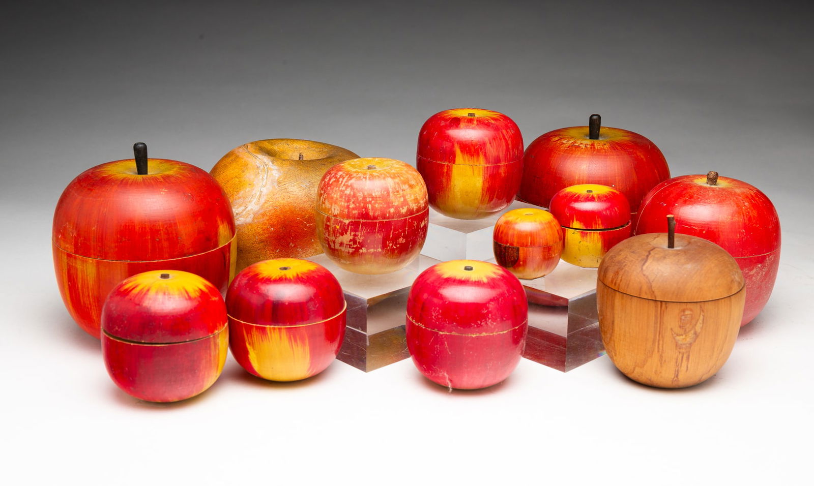 COLLECTION OF TWELVE APPLE CONTAINERS AND GAMES.: American and Japanese, Early-mid 20th Century. Assorted apple forms in two parts in several sizes, including ten Japanese painted wooden apples, an American turned wood apple, and an American painted