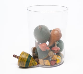 COLLECTION OF FIFTY-NINE AMERICAN WOOD SPINNING TOPS IN A BLOWN GLASS JAR.