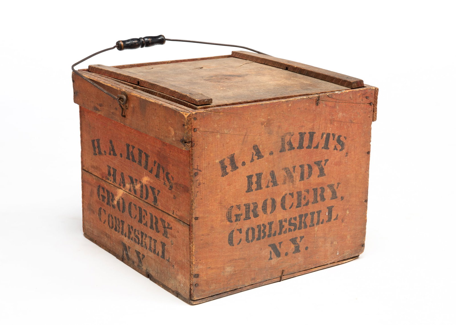 H.A. KILTS (COBLESKILL, NEW YORK) "HANDY GROCERY" RED-PAINTED EGG CARRIER.: Late 19th-early 20th Century. Wood. The crate having a wire handle ebonized wood grip and a removable lid. The interior with paper liners and dividers as well as some later plastic eggs. Two of the