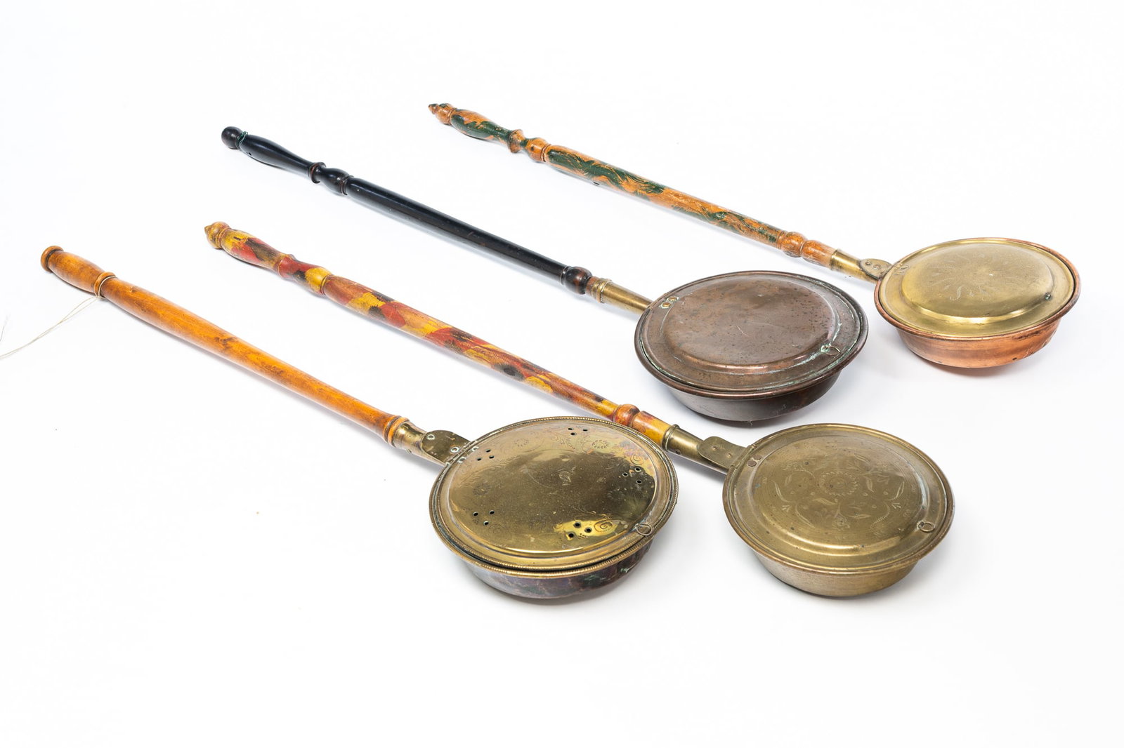 FOUR AMERICAN BED WARMERS.: 19th Century. Copper and brass pans with turned handles, two with painted decoration. 39.5"l. to 42"l.Provenance: From the Lifetime Collection of the late Deb Fisher (Lebanon, Ohio).