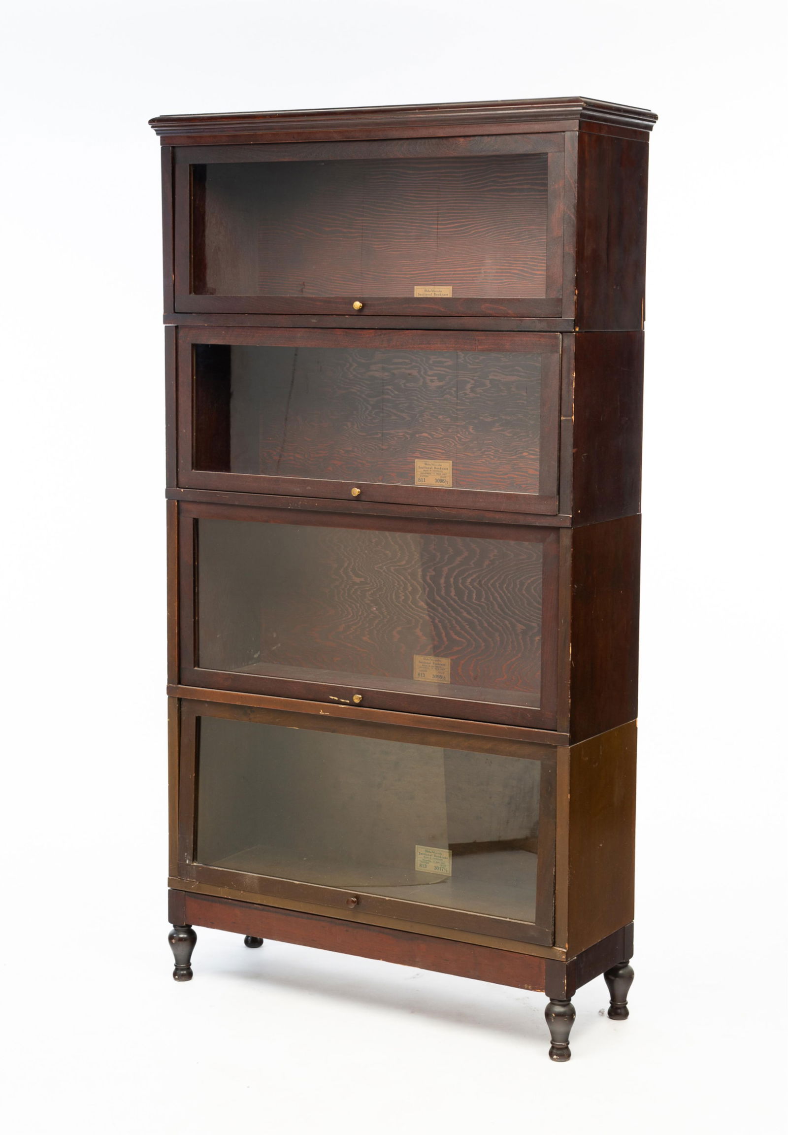 GLOBE-WERNICKE (CINCINNATI, OHIO) FOUR-STACK BARRISTER'S BOOKCASE.: American, ca. 1900. Southern gumwood. Four bookcase sections with cornice as well as base with turned feet. 66"h. 35.5"w. 12.25"d.