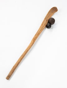 PRIMITIVE CARVED WOOD GAME STICK WITH TWO BALLS.