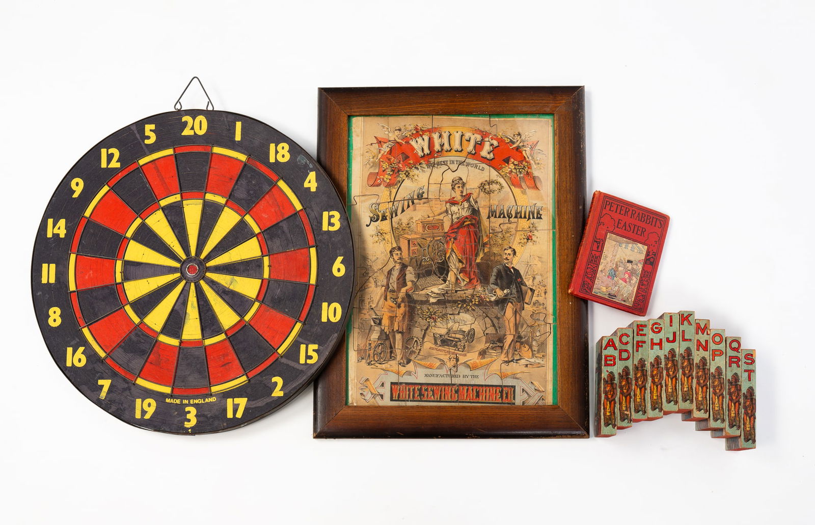 ECLECTIC LOT OF GAMES, TOYS, AND BOOK, INCL. SIGNED COPY OF PETER RABBIT'S EASTER BY LINDA STEVENS: Late 19th-20th Century. A signed 1921 copy of Peter Rabbit's Easter by Linda Stevens Almond. A framed White sewing machine advertising puzzle, 18.75"h. 14.5"w. Ten lithographed wood blocks with an