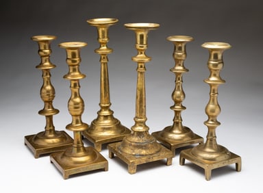 THREE PAIRS OF EASTERN EUROPEAN CAST BRASS CANDLESTICKS.