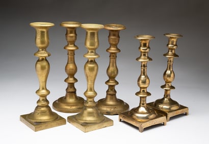 THREE PAIRS OF EASTERN EUROPEAN CAST BRASS CANDLESTICKS.