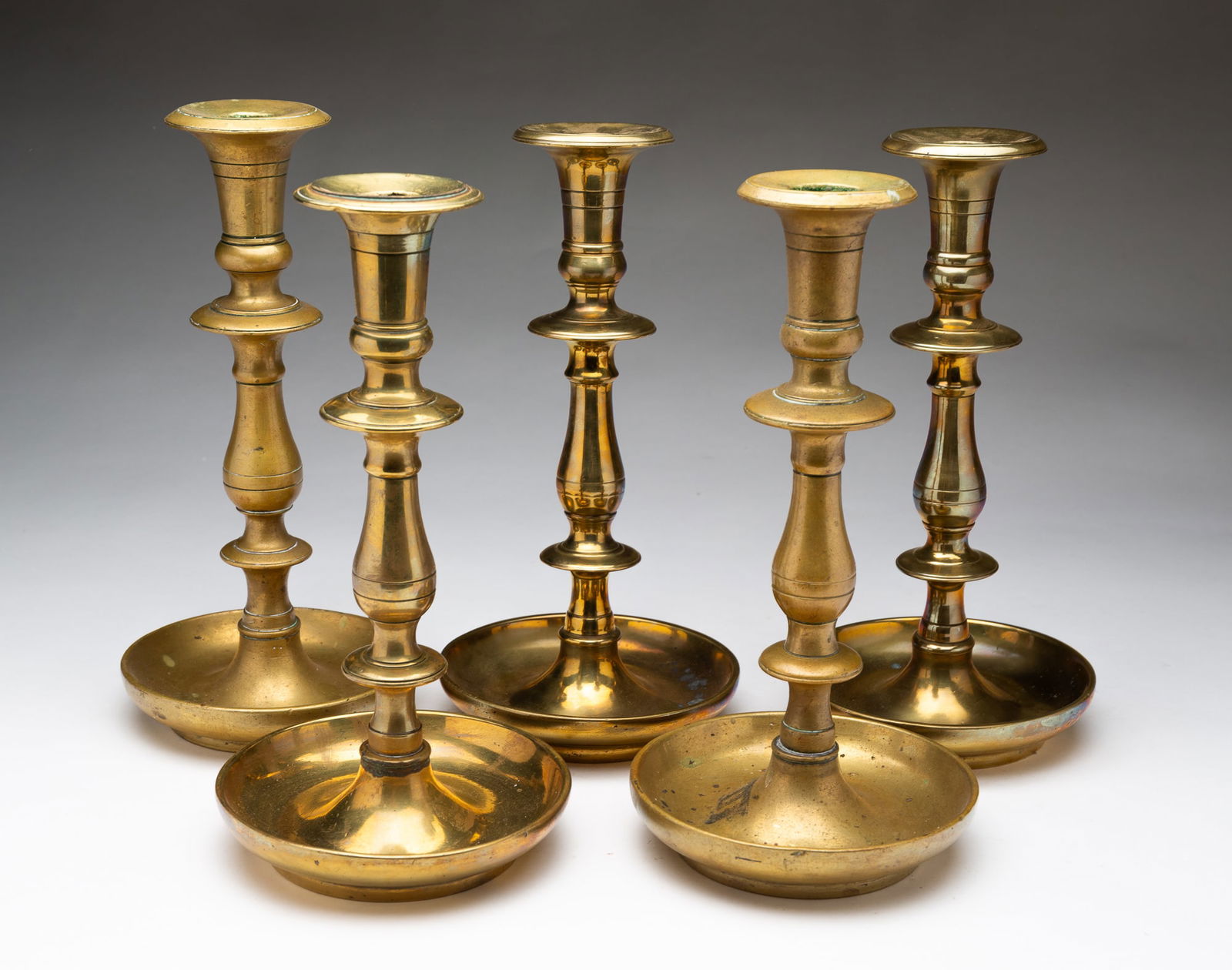 FIVE EUROPEAN CAST BRASS CANDLESTICKS. (1 of 5)