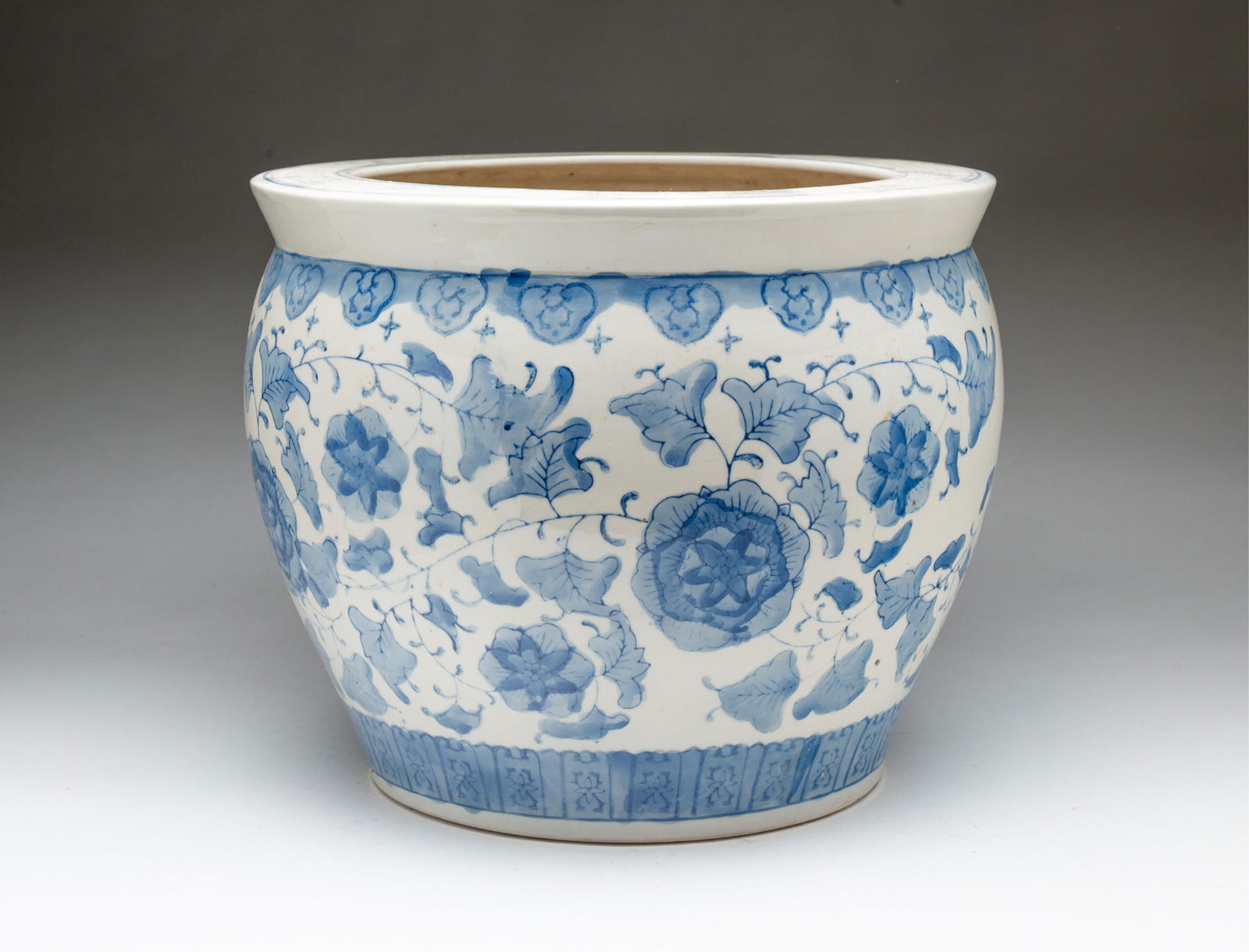 CHINESE BLUE AND WHITE PORCELAIN JARDINIERE.: 20th Century. Pronounced rim with Greek key decoration, the body with floral decoration. 10.5"h. 12.5"d.Provenance: From the Collection of Tom and Lenore Karras (Geneva, Illinois).