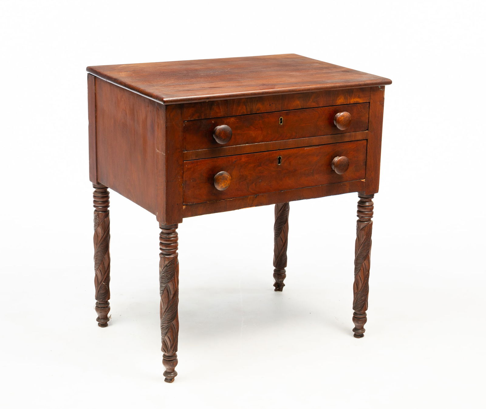 AMERICAN LATE CLASSICAL MAHOGANY TWO-DRAWER STAND.: Second quarter 19th Century. Having a rectangular top above two stacked drawers and rising on turned and foliate-carved legs. 26.75"h. 24.25"w. 16.75"d.