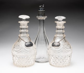 THREE GLASS DECANTERS, ONE WITH A COMBINATION LOCK STOPPER.