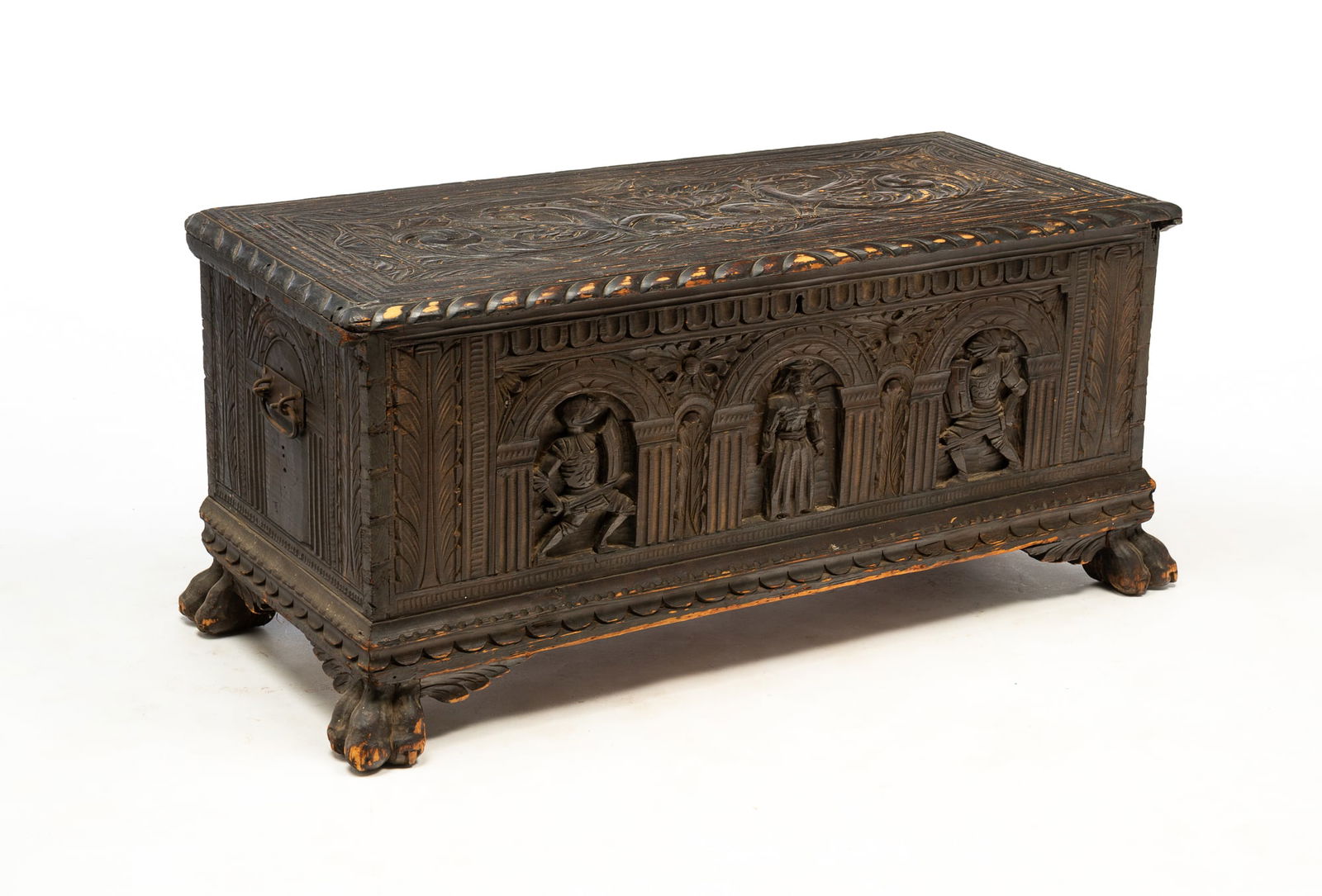 EUROPEAN RENAISSANCE REVIVAL CARVED PINE COFFER.: Possibly French, 19th Century. Having a foliate-carved, rectangular lid with gadrooned edges above a dovetailed case with interior till, iron handles, as well as a carved arcade with knights on the