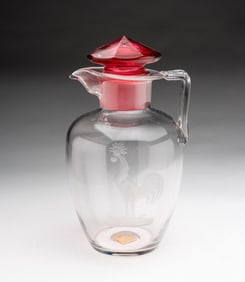 STEUBEN (CORNING, NEW YORK) ROOSTER-ETCHED CLEAR GLASS COCKTAIL PITCHER WITH CRANBERRY STOPPER.