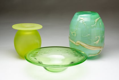 TWO GREEN ART GLASS VASES AND A BOWL.