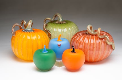 THREE SIGNED SWEDISH ORREFORS ART GLASS APPLES AND THREE SIGNED AMERICAN ART GLASS PUMPKINS.