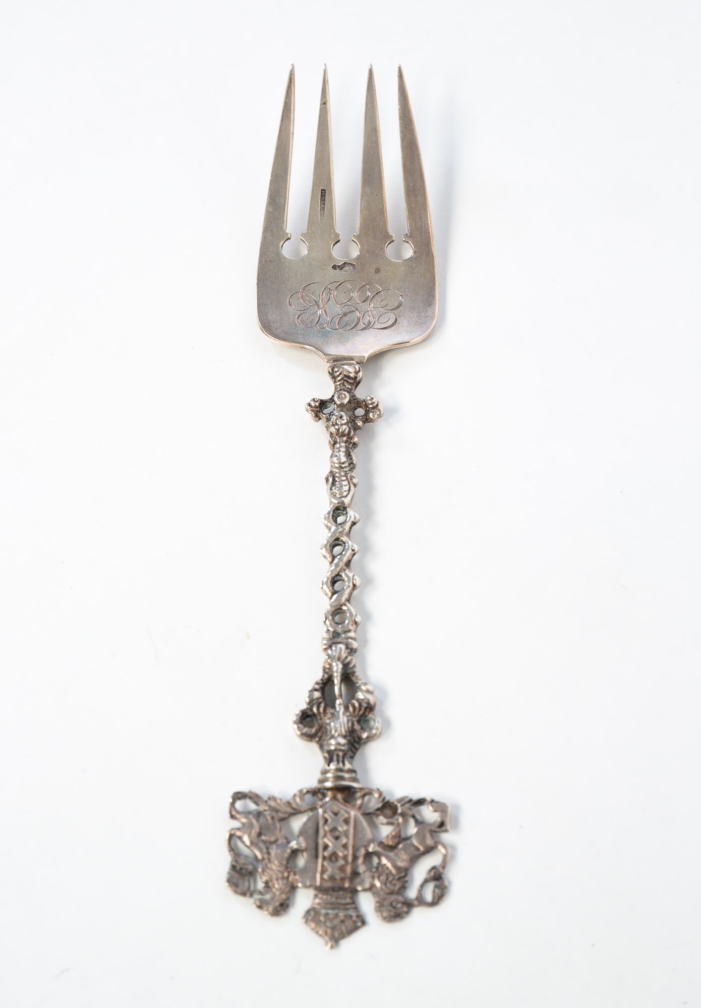 ORNATE HOLLAND STERLING SILVER FORK.: Netherlands, 19th Century. Holland marks. Fanciful top with two lions holding a crest atop an ornate, openwork handle and a monogrammed four tine fork. 7.5"l. Approximately 1.5 ozt.