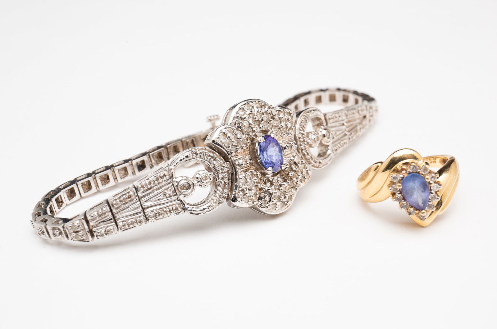 14K GOLD GEMSTONE RING AND BRACELET.: Contemporary. A 14k yellow gold ring set with a pear shaped tanzanite with diamond halo, size 5. Together with a 14k white gold cocktail bracelet set with diamond chips and a central tanzanite,