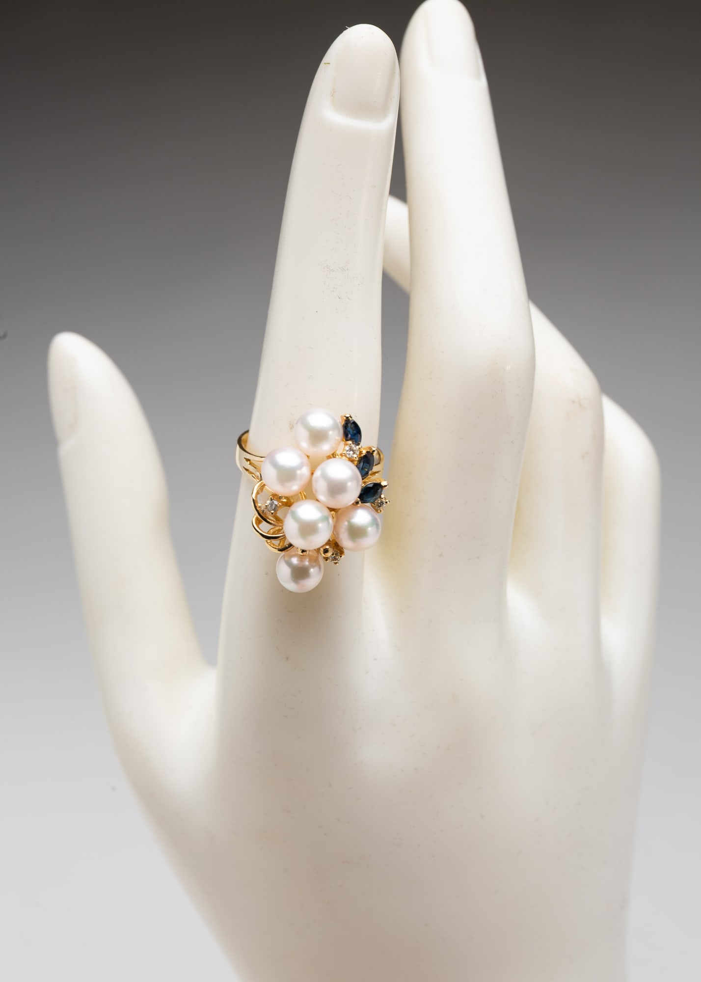 14K YELLOW GOLD PEARL, DIAMOND, AND GEMSTONE COCKTAIL RING.: Contemporary. A marked 14k yellow gold ring with six, 5 mm, pearls, three marquise-cut blue stones, possibly sapphires, and four small full-cut diamonds. Size 7.5. Approximately 5.2g.