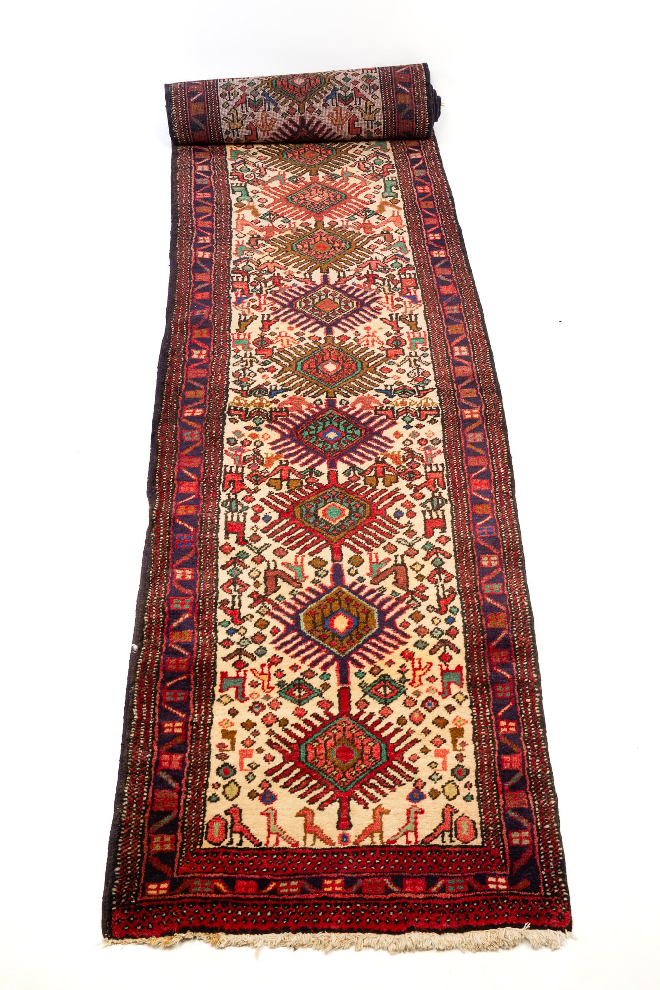 PERSIAN RUNNER.: Late 20th Century. Wool. Fifteen diamond-shaped medallions, cream field, blue and stippled borders, birds, quadrupeds, and a geometric multi-colored pattern 2'4"w. 10'11"l.