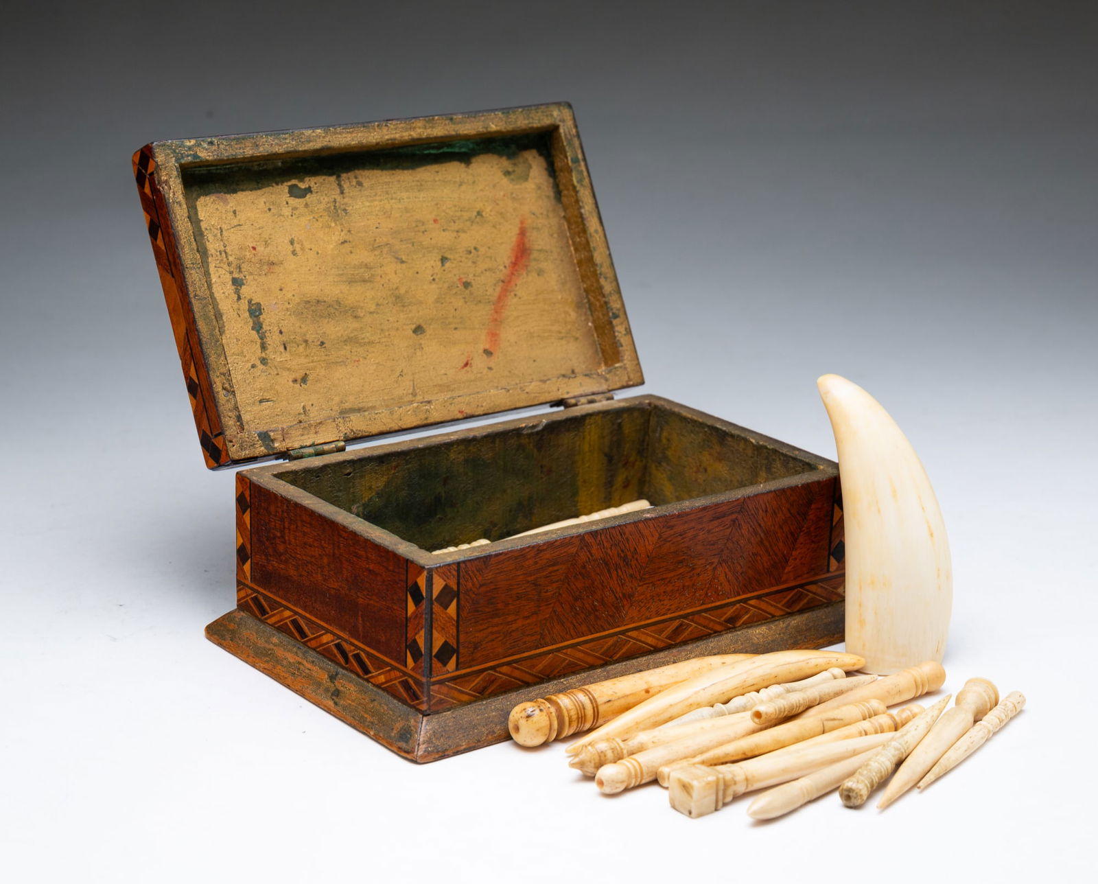 SMALL AMERICAN PARQUETRY BOX WITH NET NEEDLES.: Late 19th-20th Century. Rectangular box with gold-painted interior and containing various-sized net needles. Some are resin and some are natural materials. 2.75"h. 6.25"w.