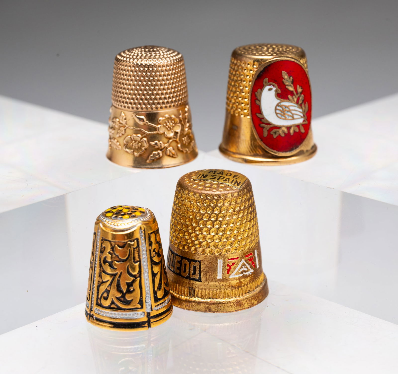 A 10K GOLD AND THREE ENAMELED BRASS THIMBLES. (1 of 4)