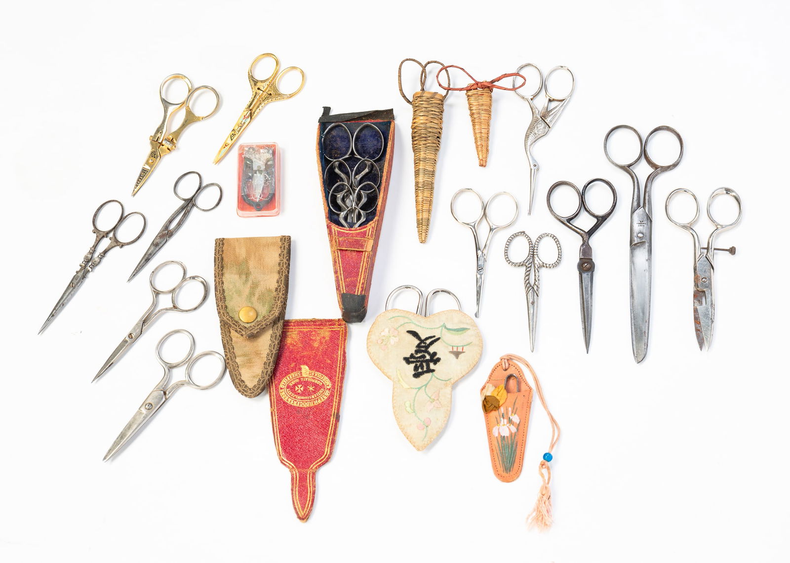 COLLECTION OF TWENTY SEWING SCISSORS.: Various nationalities, 19th-20th Century. German owl-form scissors in woven and velvet case; three sizes of Joseph Rogers & Sons, Sheffield, in marked case; Chinese scissors in embroidered case;