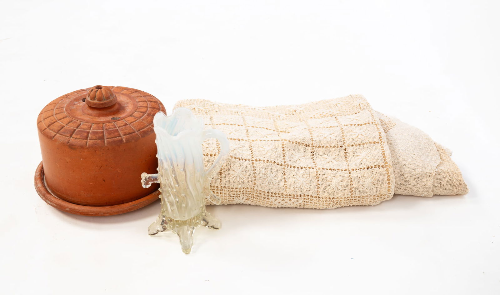 THREE HOUSEHOLD ITEMS, INCL. HANDMADE LACE TABLECLOTH.: American, 20th Century. A terracotta lidded cheese dish, an opalescent glass vase in the form of a tree trunk, and a handmade lace tablecloth. Tallest 6.75"h. Tablecloth, 52"w. 70"l.