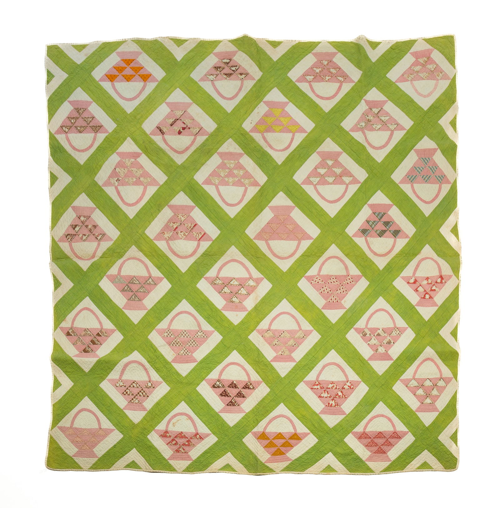 AMERICAN PIECEWORK BASKET QUILT.: Early 20th Century. Hand-stitched. Ground in green and white with baskets in patterned fabrics. Tag to back notes "Museum of American Folk Art" and "The New York Quilt Project 1988-1991".Provenance: F