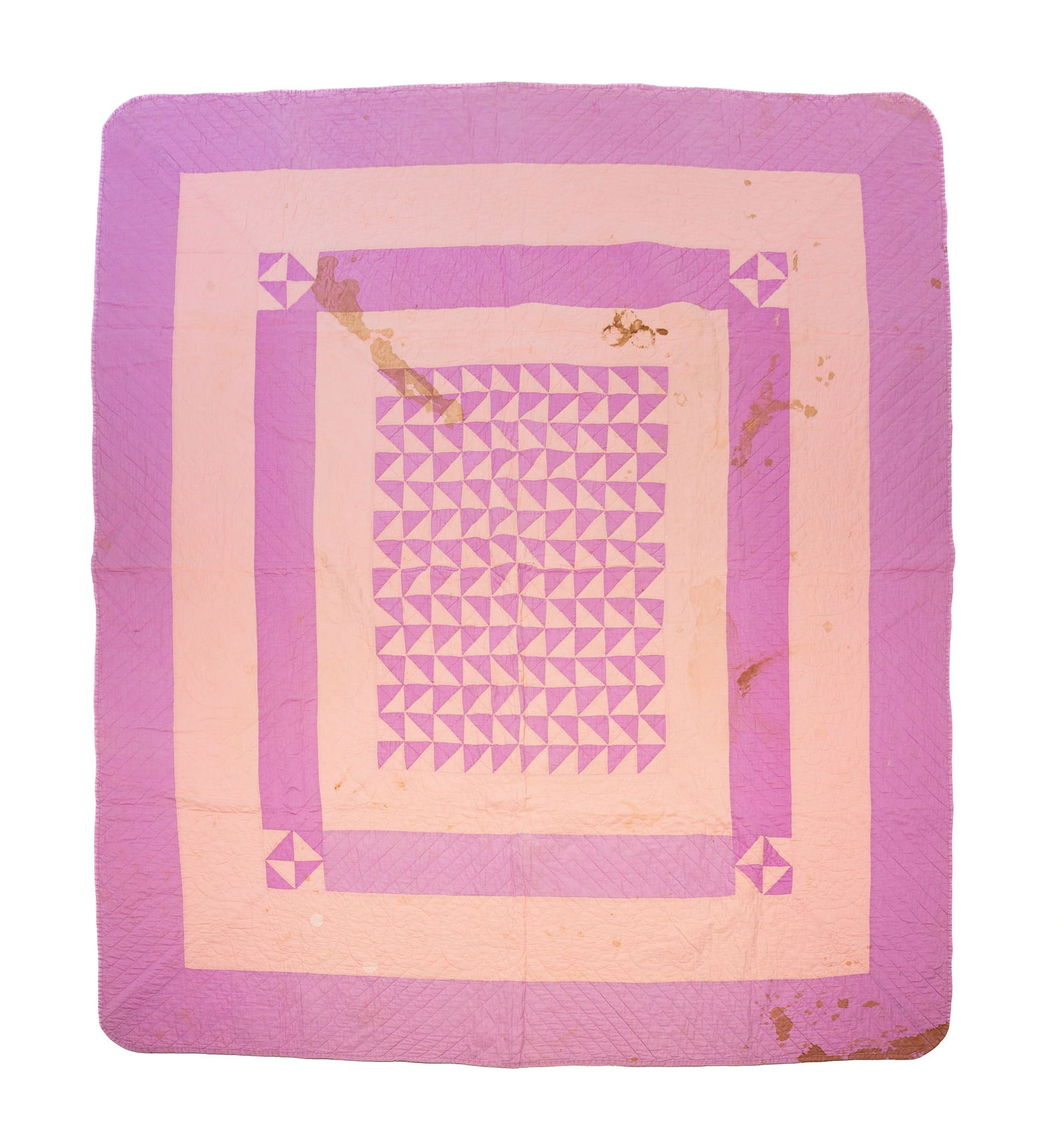 AMERICAN COTTON PIECEWORK QUILT.: First half 20th Century. Hand-stitched in solid colored peach and purple fabric. Wide borders with a triangle and square geometric pattern.Provenance: From the Lifetime Quilt and Textile Collection