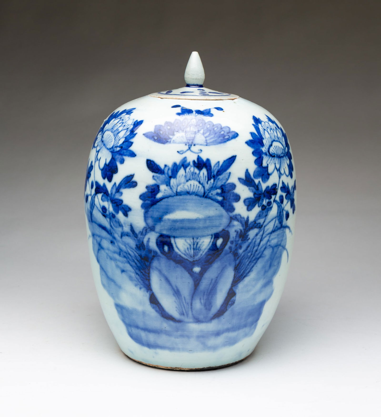 CHINESE PORCELAIN BLUE AND WHITE LIDDED JAR.: Ca. 1800. Of ovoid form and having a lid with a finial, the body decorated with a butterfly and peonies.Provenance: From the Collection of Tom and Lenore Karras (Geneva, Illinois). 13"h.