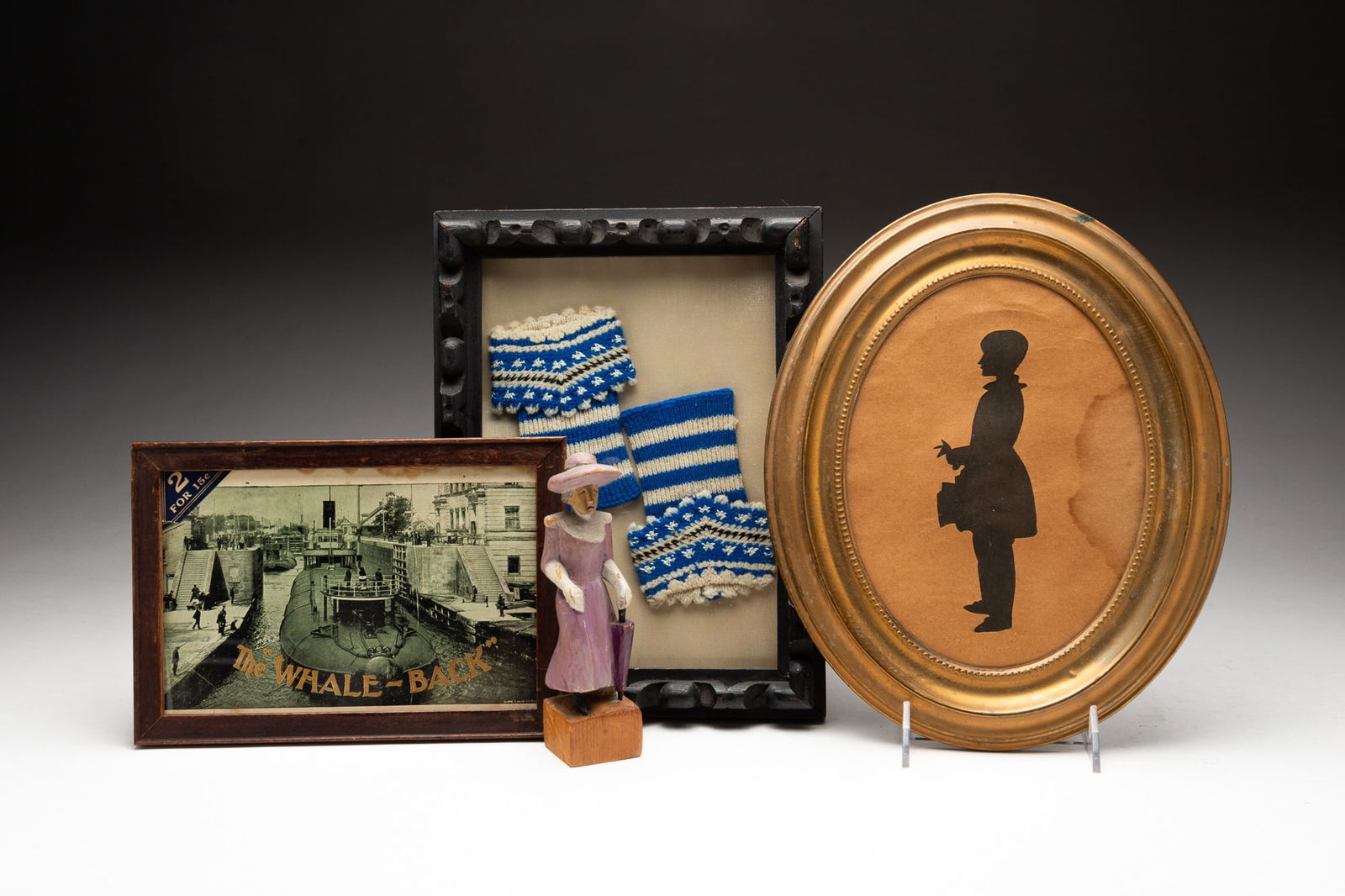 ECLECTIC DECORATIVE GROUPING, INCL. "NANTUCKET LADY" FOLK ART CARVING.: American, 19th-20th Century. A carved wood figure of a woman in a purple dress with umbrella, "Nantucket Lady" and initials "S.D.G. 1943" to bottom. A framed Whale-Back cigar box lid, in wood frame be