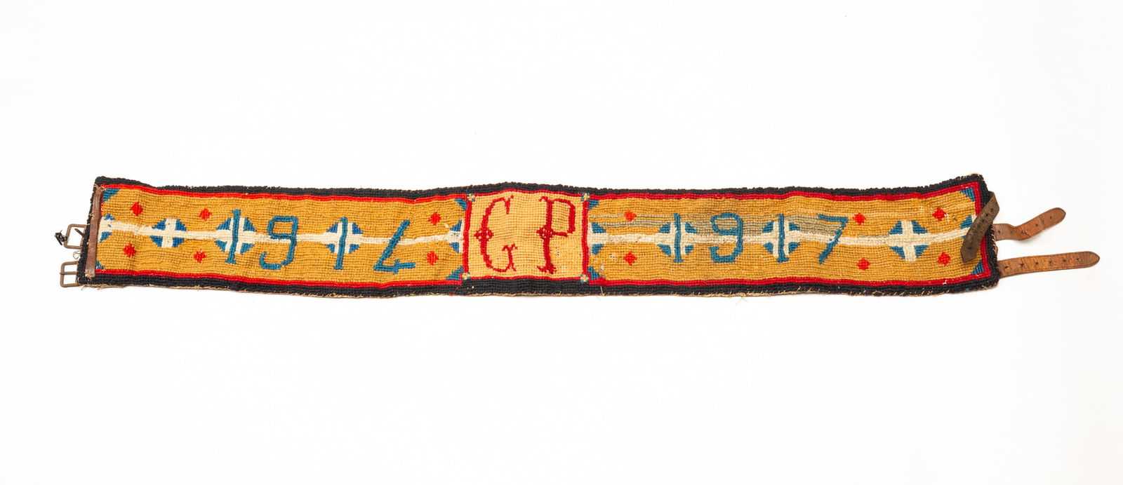 AMERICAN NEEDLEWORK BELT WITH LEATHER ACCENTS, DATED 1914 AND 1917.: Thick needlework belt that reads "1914 GP 1917" with three leather straps. 4"h. 34.5"l. (including buckles)