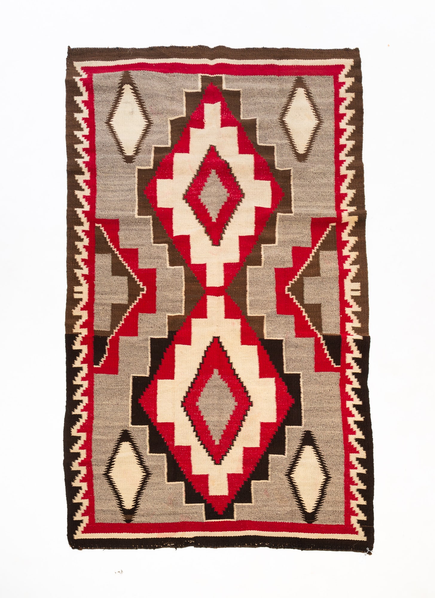 NAVAJO FLAT WEAVE RUG.: Mid-20th Century. Geometric patterns in red, white, brown, and black throughout. 3'10"w. 6'7"l.