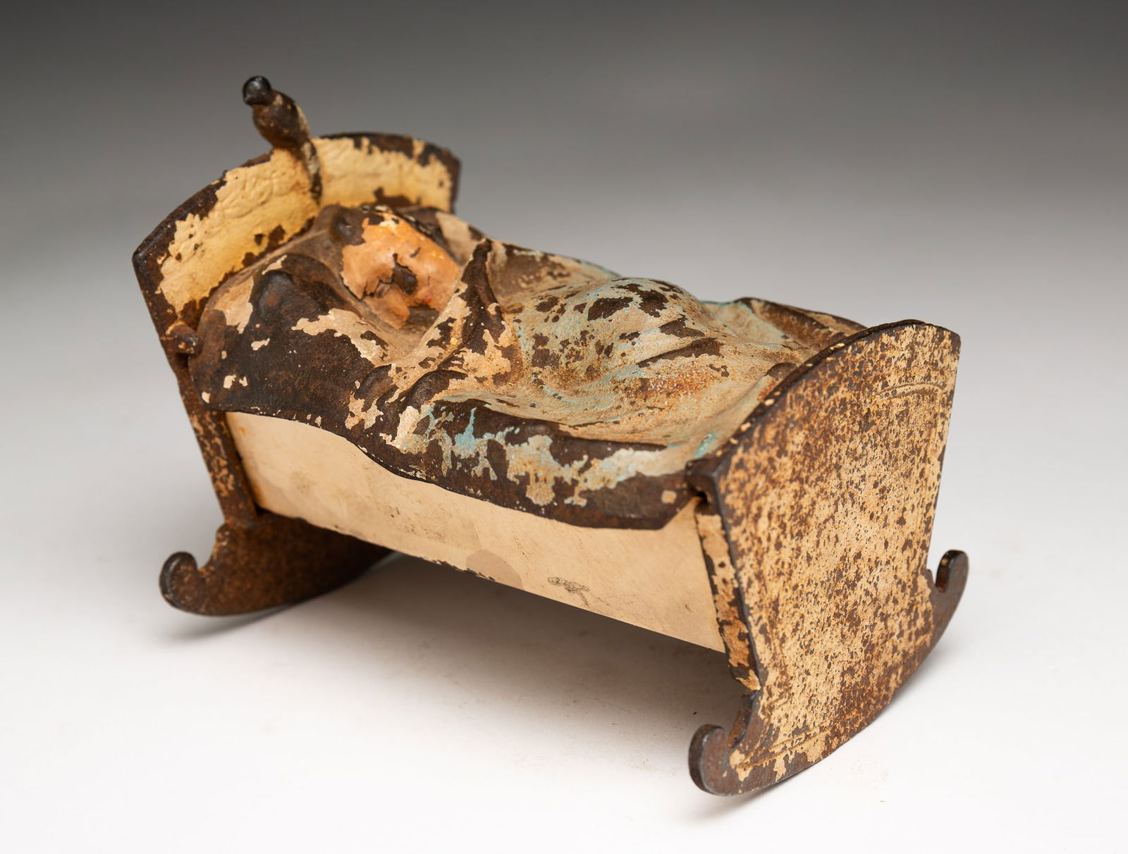 ATTRIBUTED TO HUBLEY (PENNSYLVANIA) PAINTED CAST IRON AND TIN BABY IN CRADLE STILL BANK. (1 of 4)