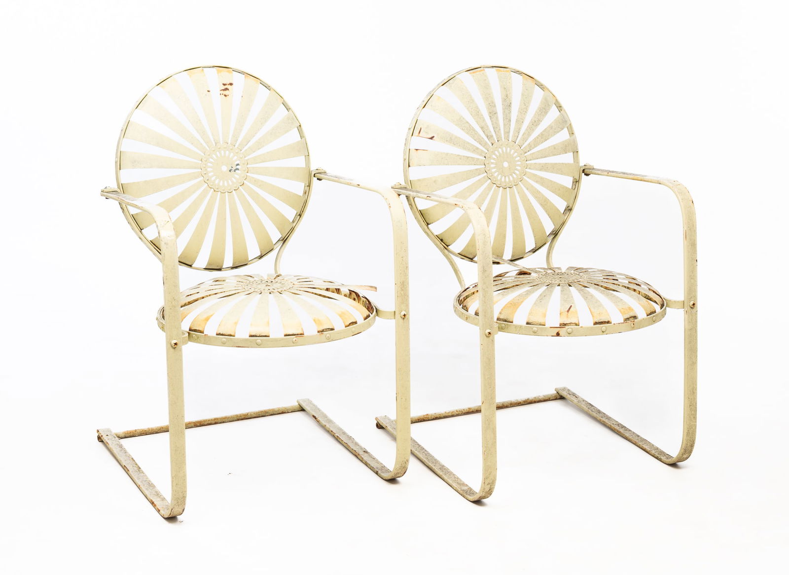 ATTRIBUTED TO FRANCOIS CARRÉ (FRENCH) PAIR OF PAINTED IRON SUNBURST GARDEN ARMCHAIRS.: Mid-20th Century. Strap iron design of a sunburst with pierced center on back and seat, flat bent tube arms and legs, painted off-white.Provenance: From the Lifetime Collection of Darwin D. Bearley. 3